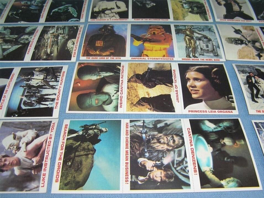 Three rows of collectible cards lay on a blue table. Each card depicts a character and short description of the scene.